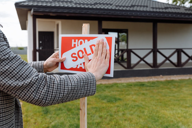 Real estate agent sets up sold sign
